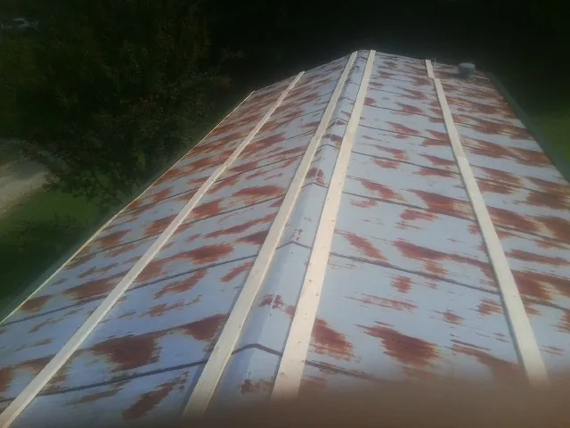 Rusted metal roof panels with new wood purlins before replacement — Storm Damage Roof Repair in Buhl by Roofing Brothers