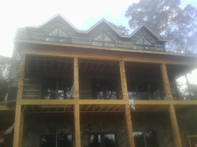 Dormers and porch framing on a large log home under construction — Roof Coating work by our crew in Buhl
