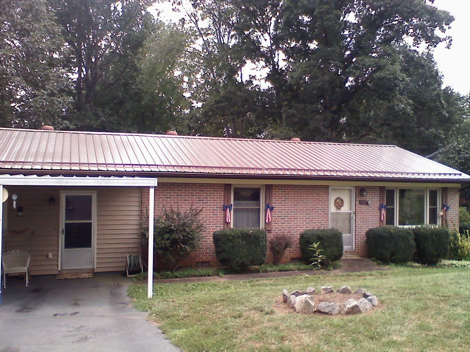 Bronze metal roof and carport on a brick ranch home — Roof Repair work by our crew in Buhl